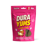 Bright pink pouch of DuraYums Lickin’ Lamb single-ingredient dog treats with bold white and yellow branding, cartoon lamb illustration, visible lamb slices, and labels promoting natural crunch, 100 percent Canadian, and pup approved.