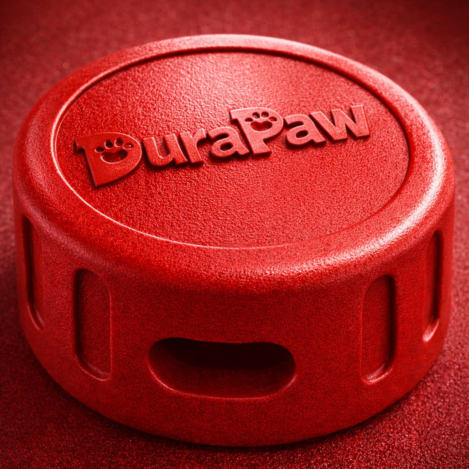Red DuraPaw ultra durable red puck dog toy on a red background