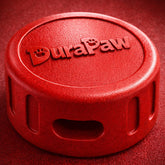 Red DuraPaw ultra durable red puck dog toy on a red background
